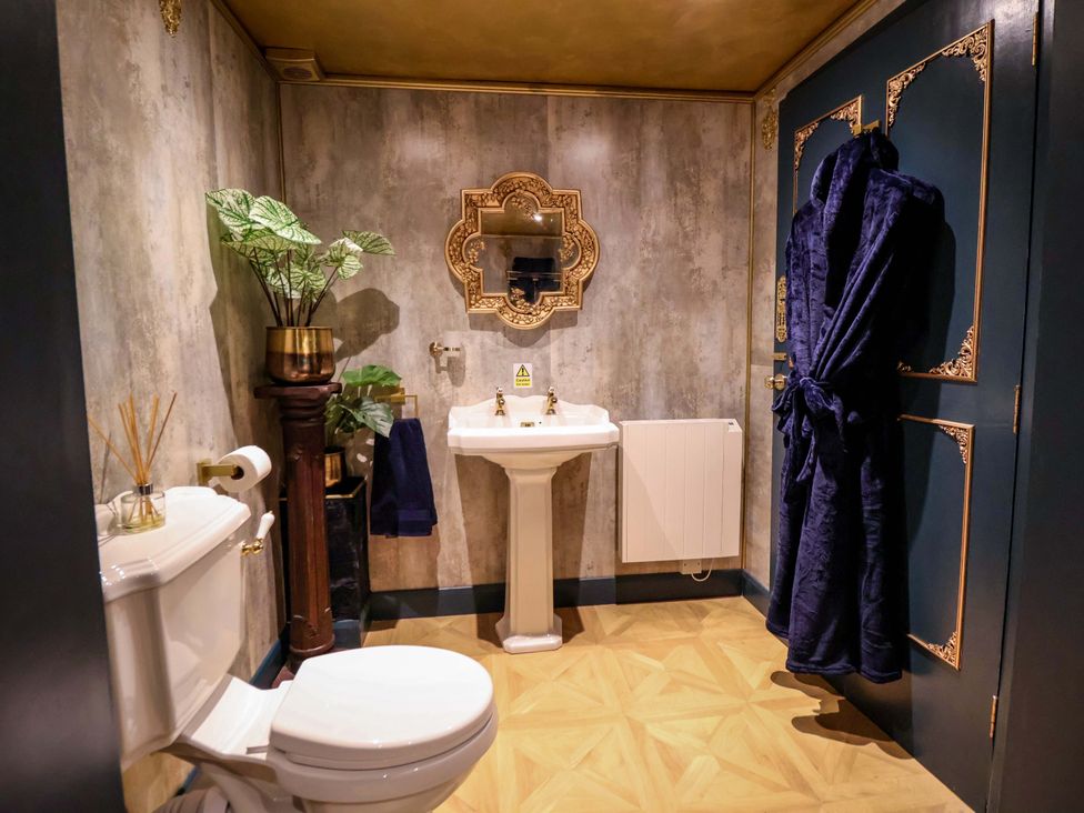 A bathroom with a sink, toilet, and plant at The Hollow in Holywell