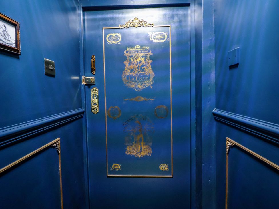 A decorative door with gold accents in a hallway at The Hollow in Holywell