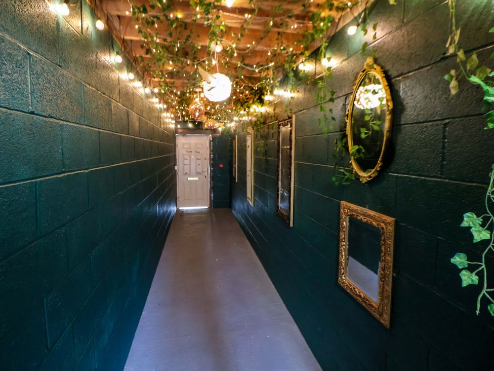 A hallway with mirrors and lights at The Hollow in Holywell