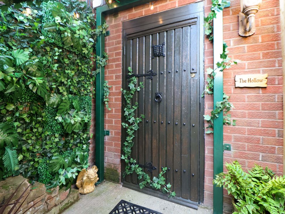 An entrance door surrounded by greenery at The Hollow in Holywell
