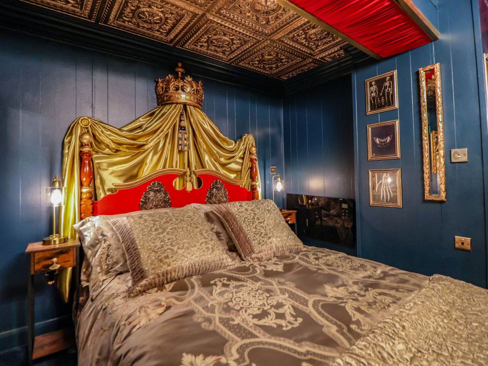 A bedroom with a decorative bed and wall art at The Hollow in Holywell