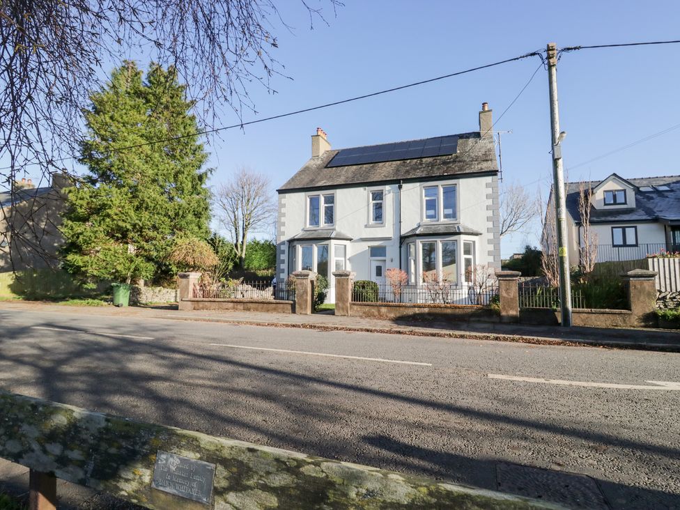 A house with solar panels and trees at Rocklands in Shap