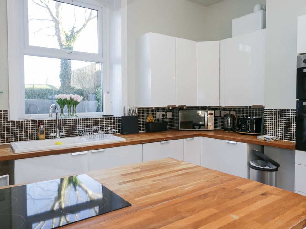 A kitchen with a sink, microwave, and kitchen island at Rocklands in Shap