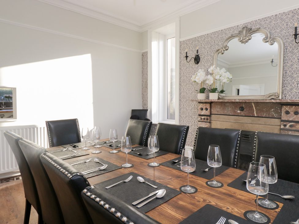 A dining room with a large table set for meals at Rocklands in Shap