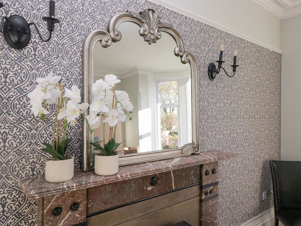 A living room with a mirror and flowerpots at Rocklands in Shap