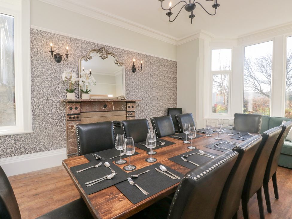 A dining room with a long table set for dinner at Rocklands in Shap