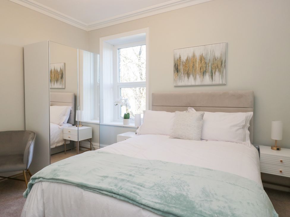 A bedroom with a bed and mirror at Rocklands in Shap