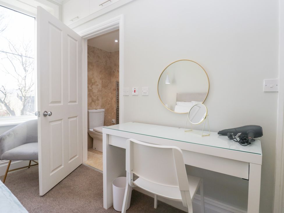 A room with a desk and chair leading to a bathroom at Rocklands in Shap