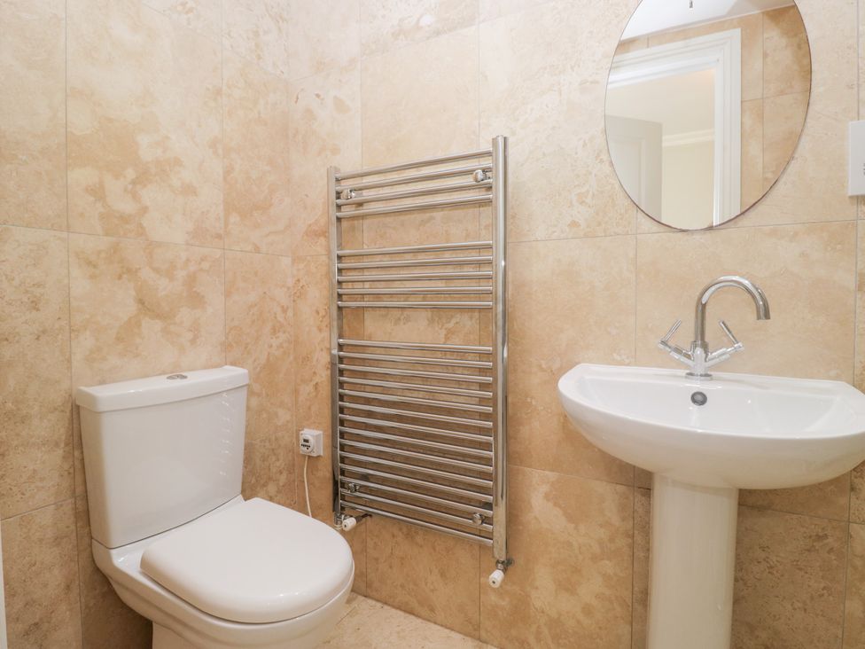A bathroom with a toilet, sink, and towel radiator at Rocklands in Shap