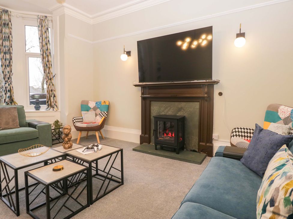 A living room with a television and fireplace at Rocklands in Shap