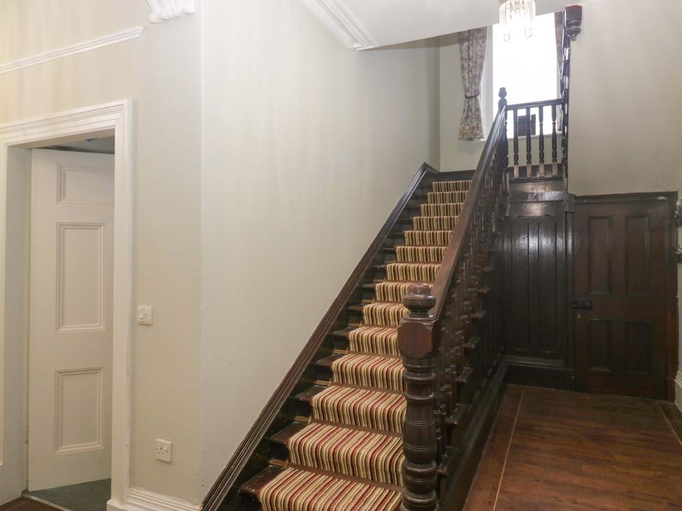 A staircase and light fixture in the hallway at Rocklands in Shap