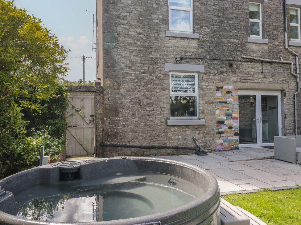 An outdoor area with a hot tub and stone wall at Rocklands in Shap