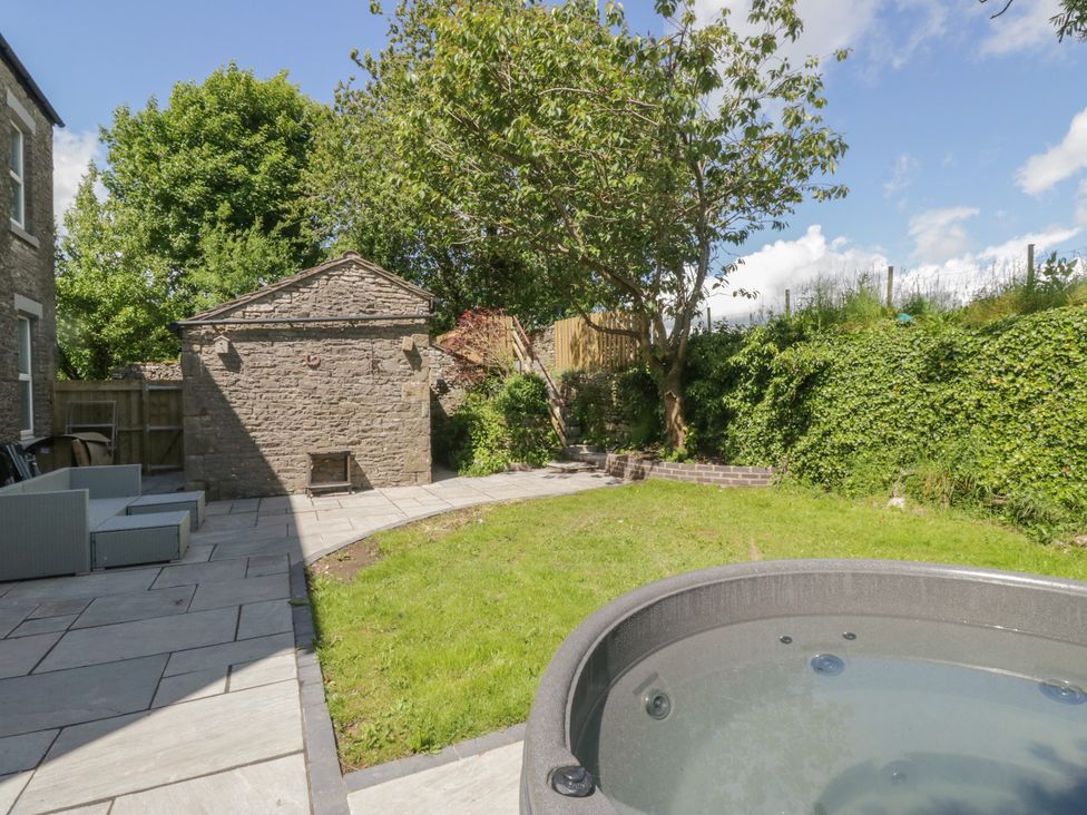 A garden with a hot tub and storage shed at Rocklands in Shap
