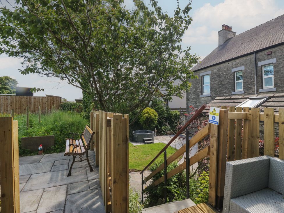 A garden with a bench and hot tub at Rocklands in Shap