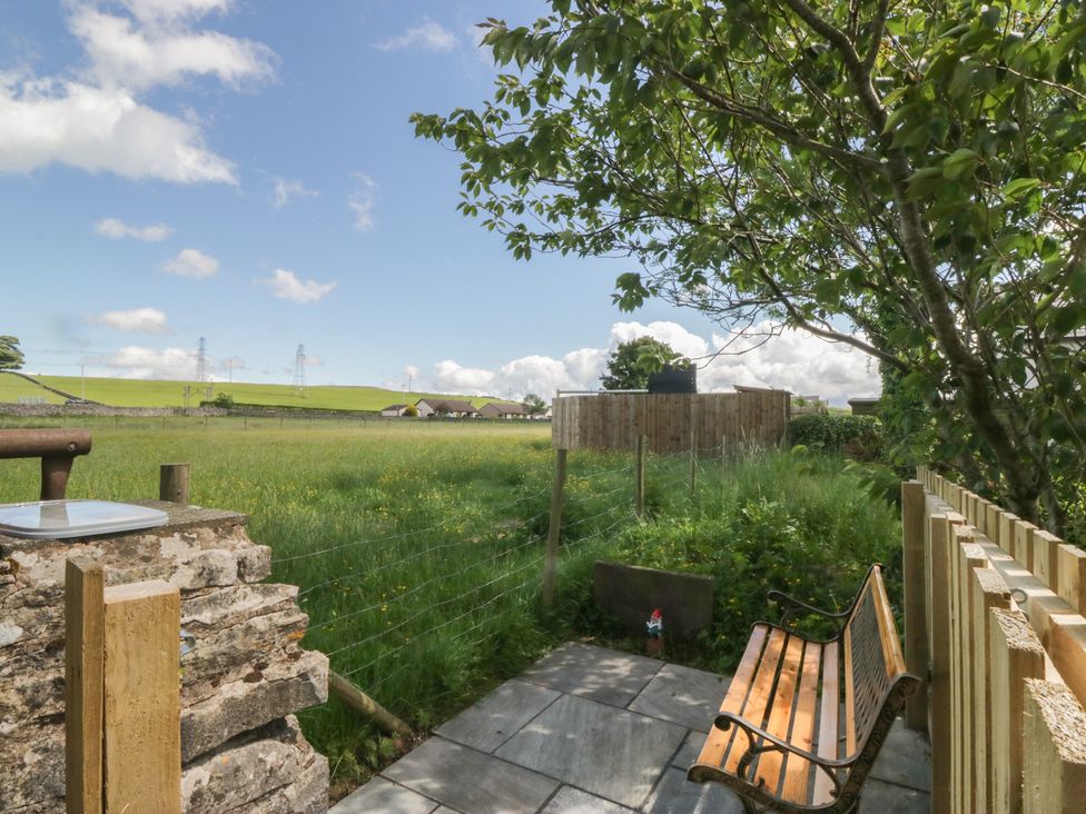 A garden with a bench and stone wall at Rocklands in Shap