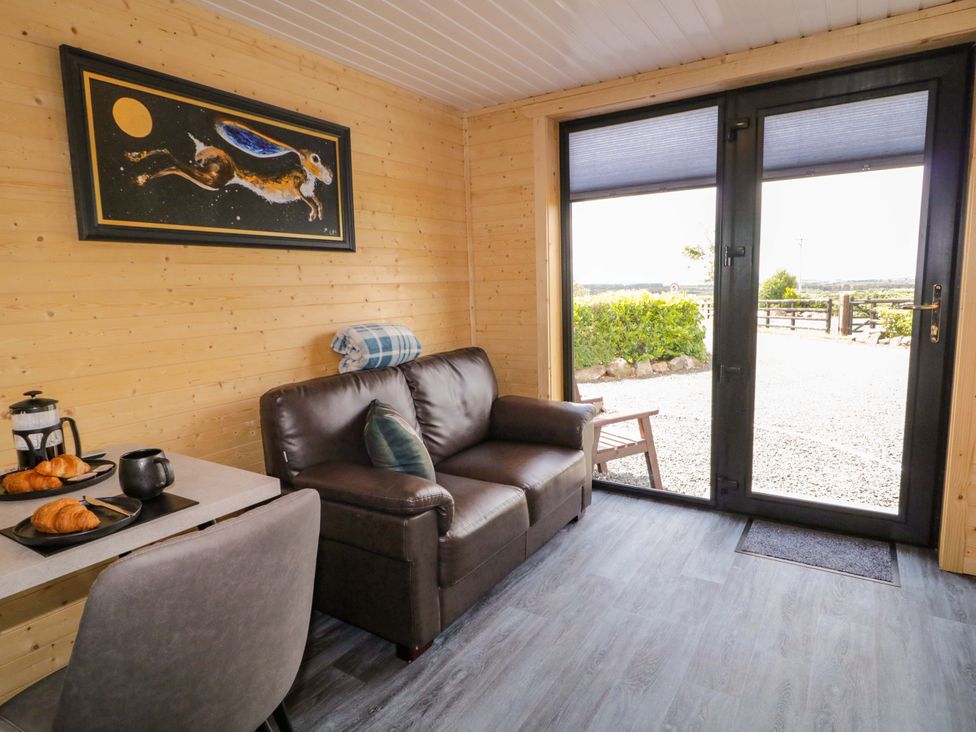 A snug with a sofa and coffee table at Alken The Hare in Bushmills