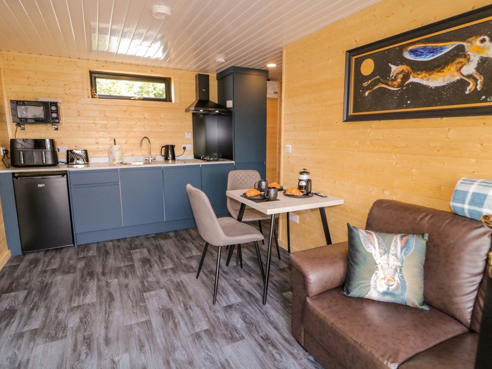 A kitchen with table and sofa at Alken The Hare in Bushmills