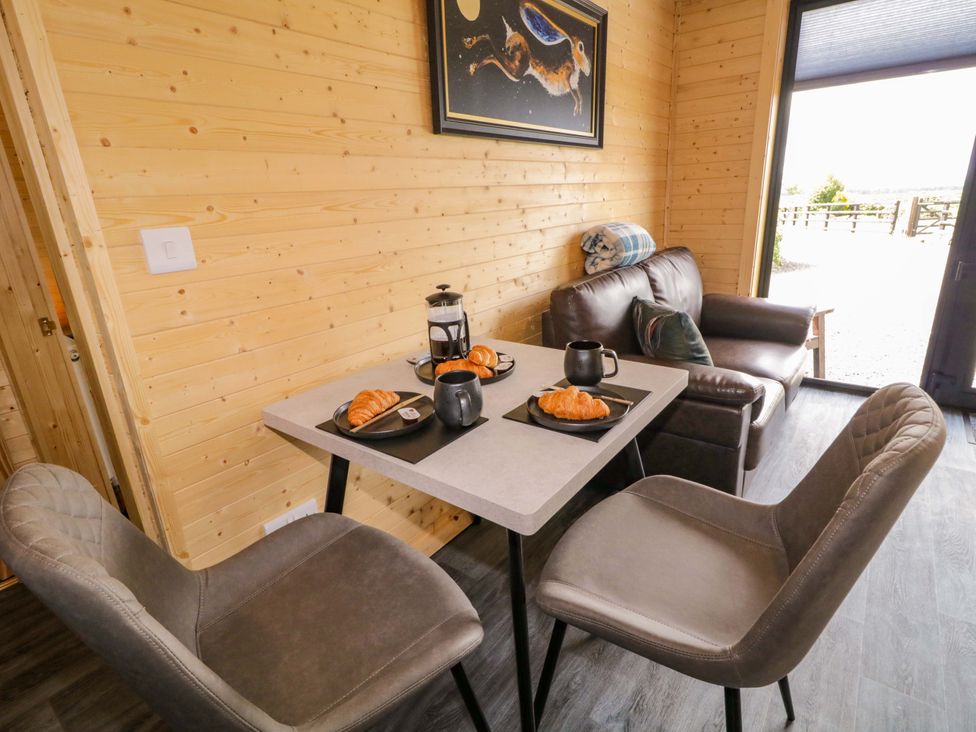 A dining area with a table and chairs at Alken The Hare in Bushmills