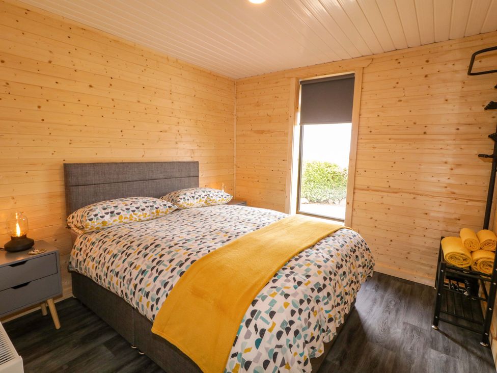 A bedroom with a bed and window at Alken The Hare in Bushmills