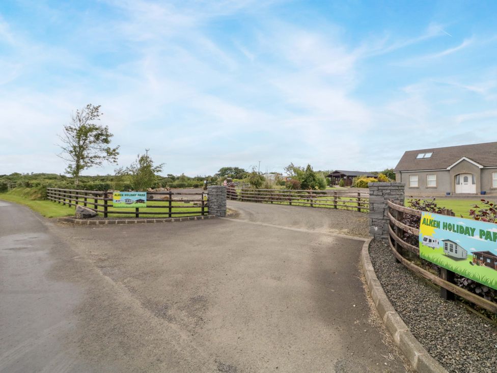 A view of Alken Holiday Park entrance with signs and trees in Bushmills
