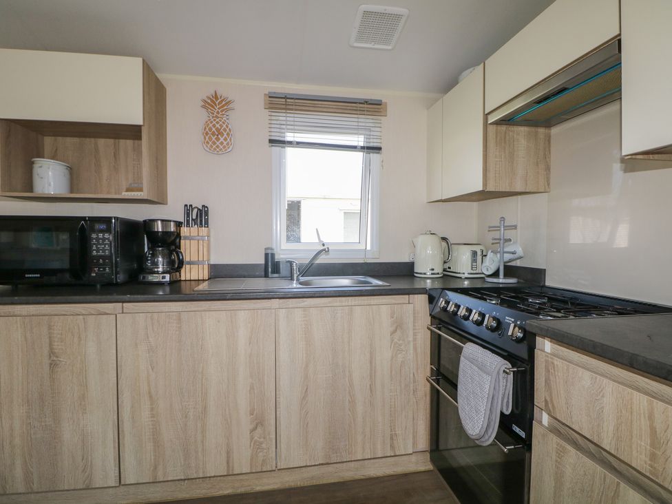 A kitchen with appliances including a microwave and coffee maker at Tower View Number 34 in Pevensey