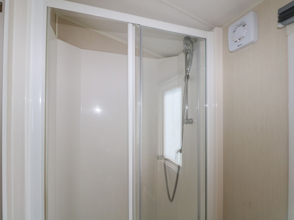 A shower with glass doors at Tower View Number 34 Pevensey