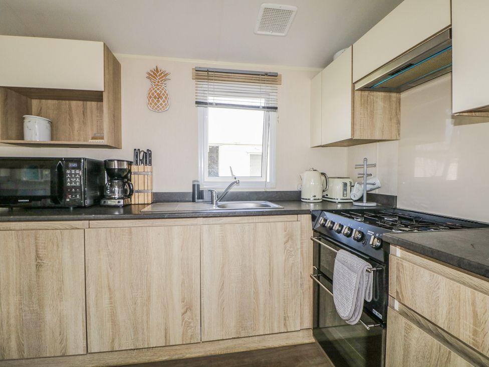 A kitchen with appliances and cabinetry at Tower View Number 34 Pevensey Bay