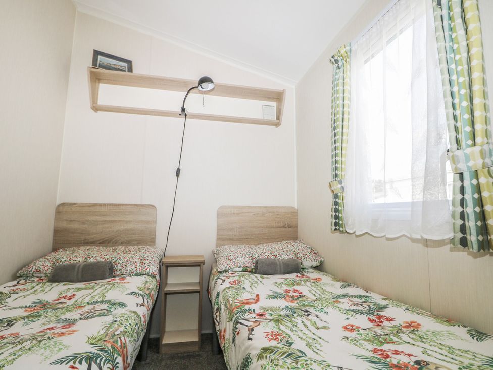 A bedroom with two beds and a shelf at Tower View Number 34 Pevensey Bay