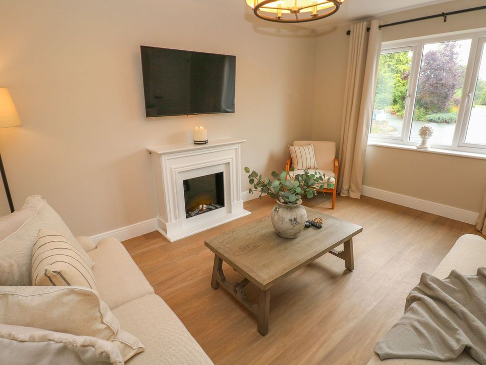 A living room with a television and fireplace at Hafan Y Gof Newcastle Emlyn