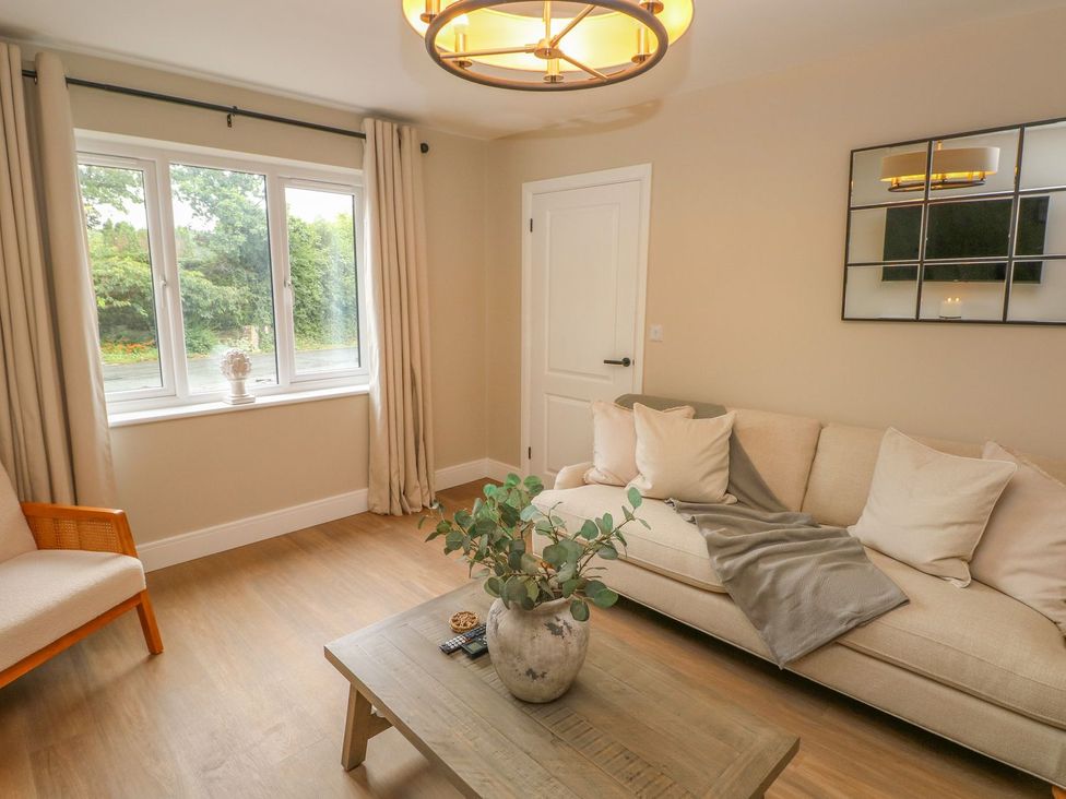 A living room with a sofa and coffee table at Hafan Y Gof, Newcastle Emlyn