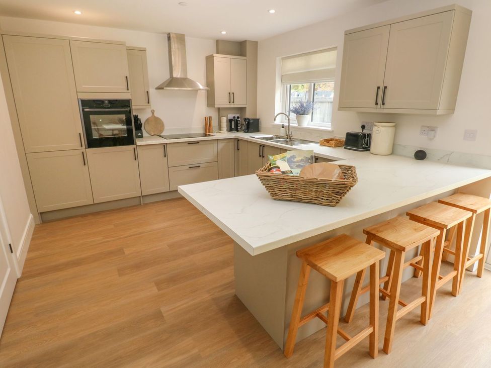 A kitchen with a countertop and stools at Hafan Y Gof in Newcastle Emlyn