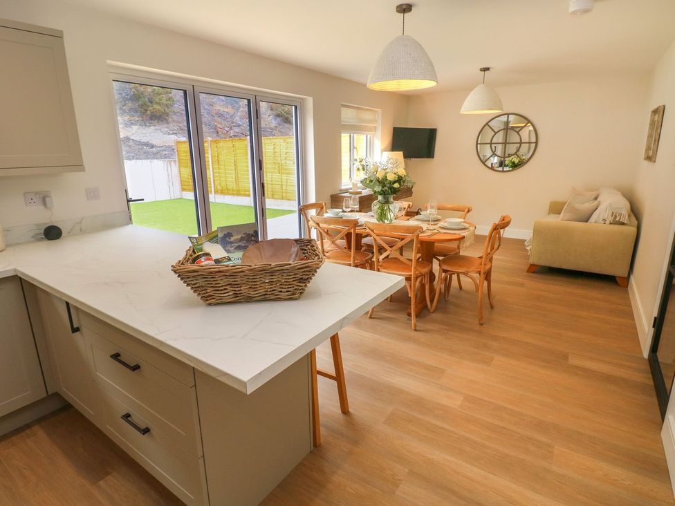 A kitchen and dining area with a table and chairs at Hafan Y Gof Newcastle Emlyn