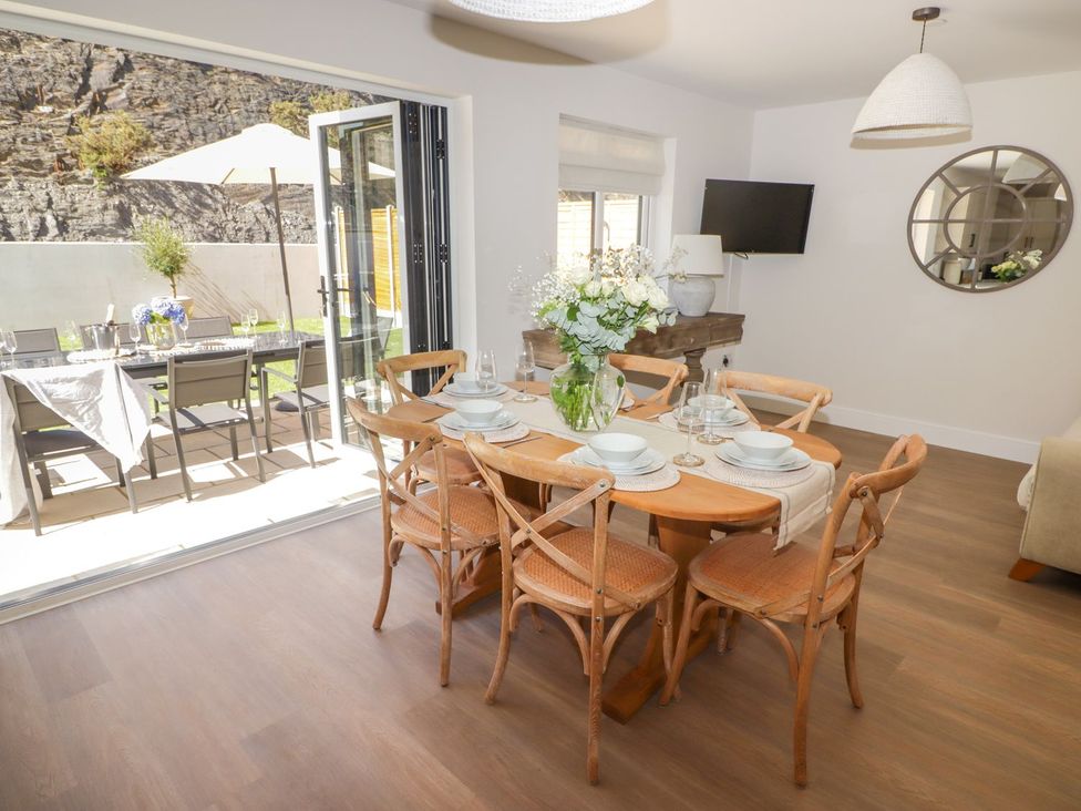 A dining room with a table and chairs visible at Hafan Y Gof Newcastle Emlyn