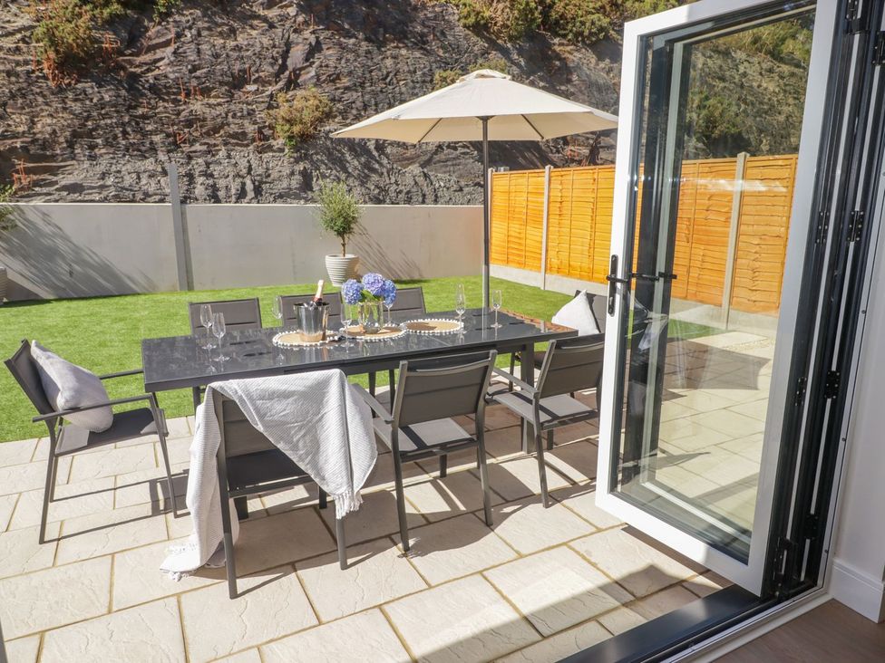 A garden with a dining table and chairs at Hafan Y Gof in Newcastle Emlyn