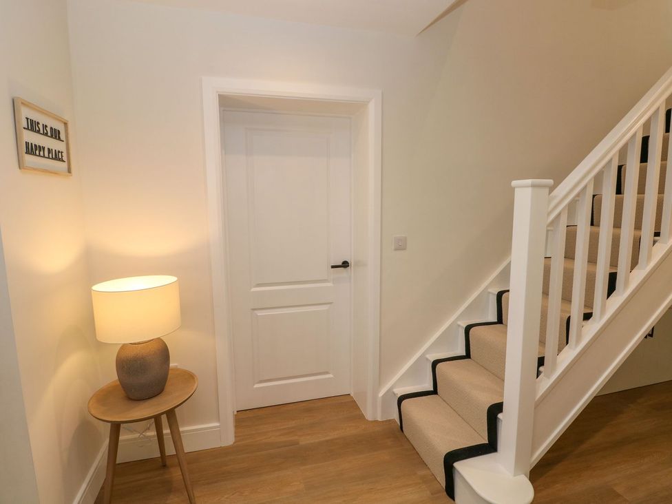 A hallway with a staircase and lamp at Hafan Y Gof Newcastle Emlyn