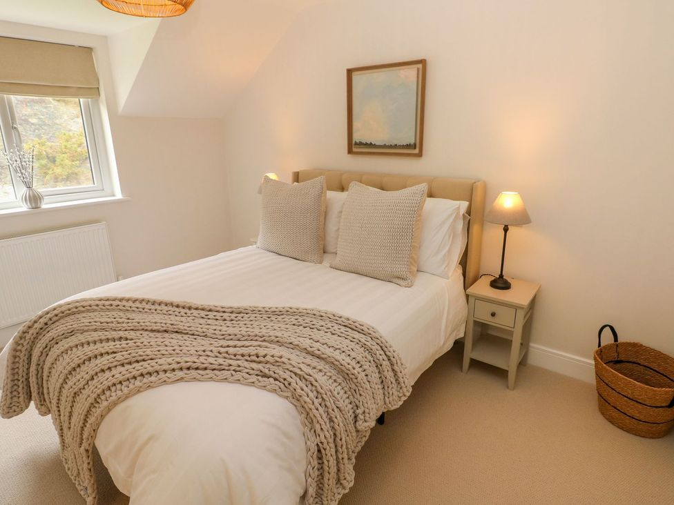 A bedroom with a bed and bedside table at Hafan Y Gof in Newcastle Emlyn