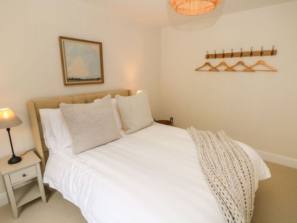 A bedroom with a bed and coat hangers at Hafan Y Gof in Newcastle Emlyn