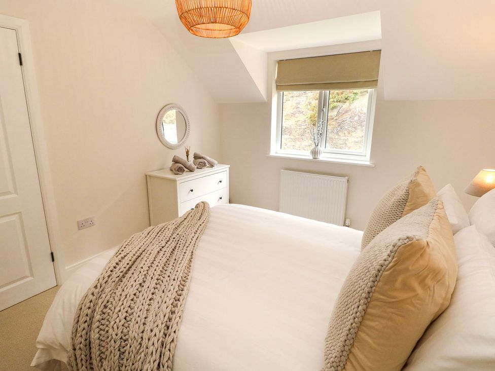 A bedroom with a bed and dresser at Hafan Y Gof in Newcastle Emlyn