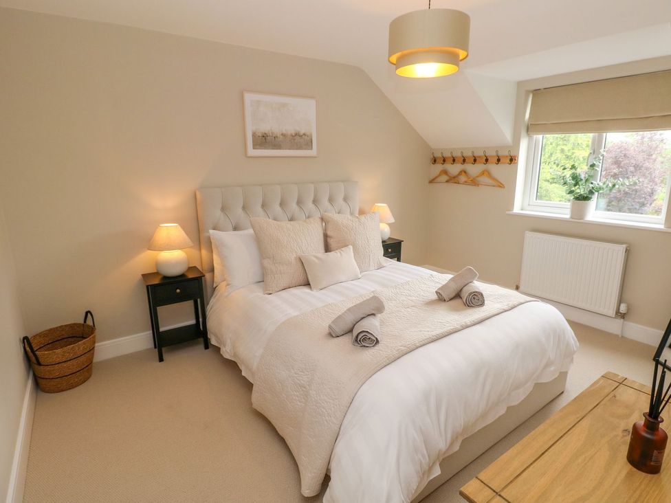 A bedroom with a bed and nightstands at Hafan Y Gof Newcastle Emlyn