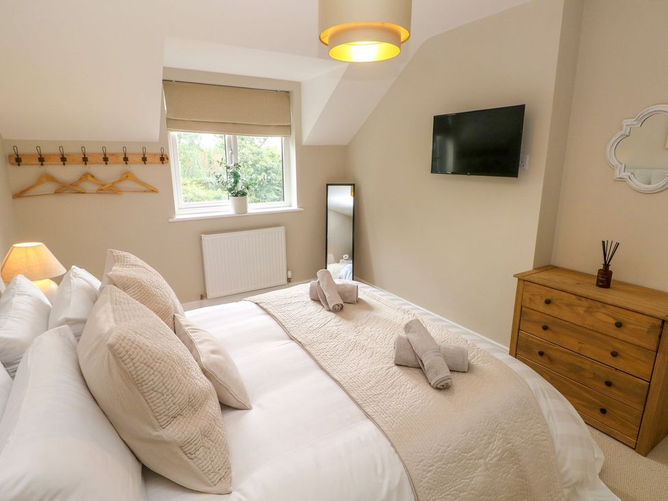 A bedroom with a bed, television, and dresser at Hafan Y Gof in Newcastle Emlyn