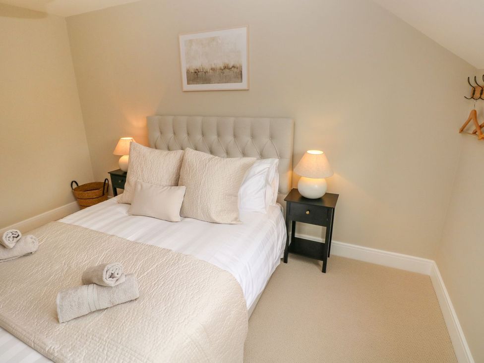 A bedroom with a bed and nightstand at Hafan Y Gof in Newcastle Emlyn