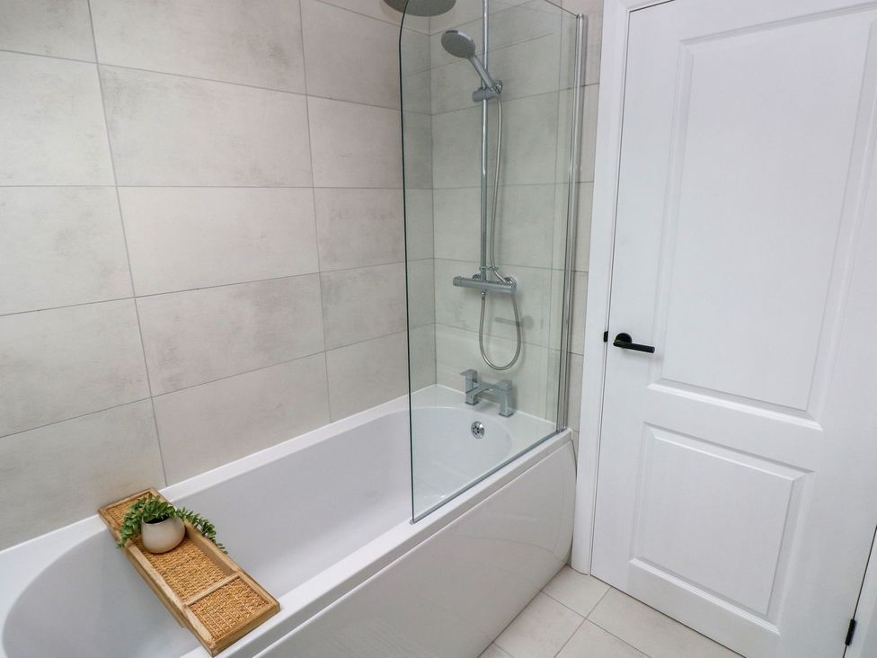 A bathroom with a bathtub and shower in Hafan Y Gof Newcastle Emlyn