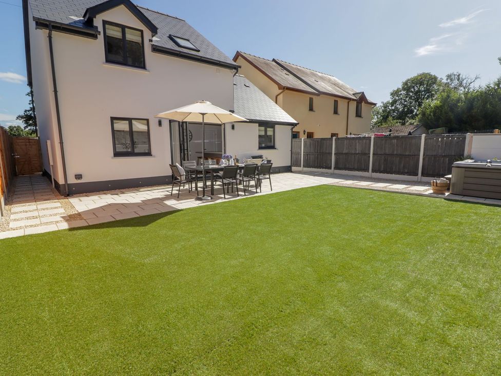 A garden with a patio, table and chairs at Hafan Y Gof in Newcastle Emlyn