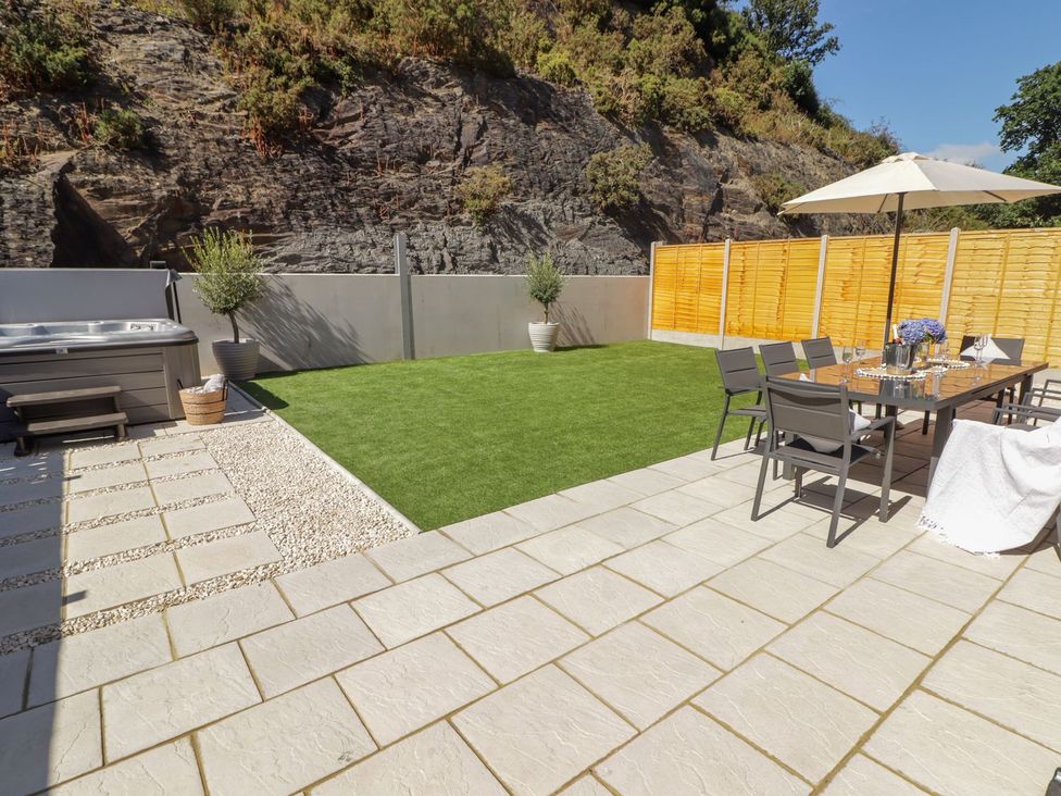 A garden with a hot tub and seating area at Hafan Y Gof Newcastle Emlyn