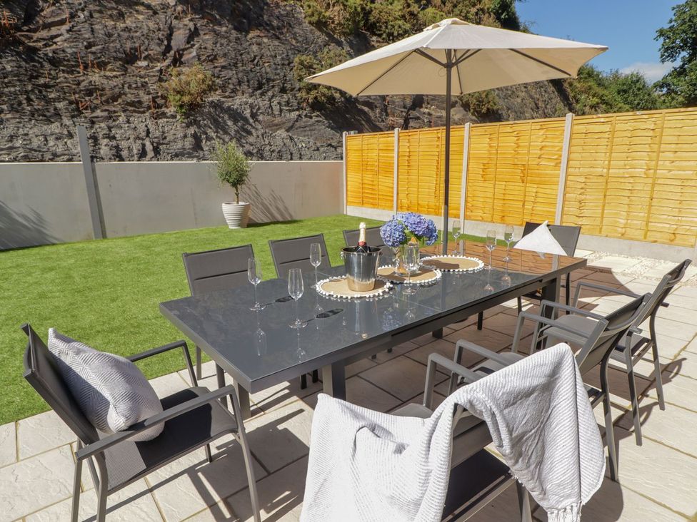 An outdoor dining area with a table and chairs at Hafan Y Gof Newcastle Emlyn