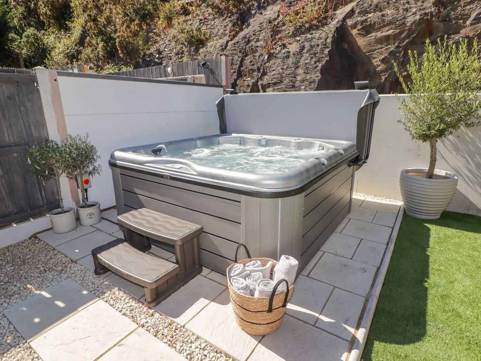A hot tub with steps and towels in the garden at Hafan Y Gof Newcastle Emlyn