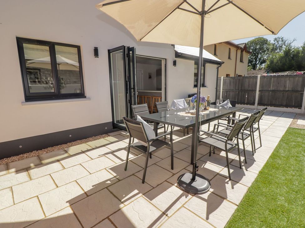 An outdoor dining area with a table and chairs at Hafan Y Gof Newcastle Emlyn