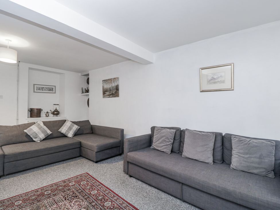 A living room with gray sofas and a rug at Maindy Lodge