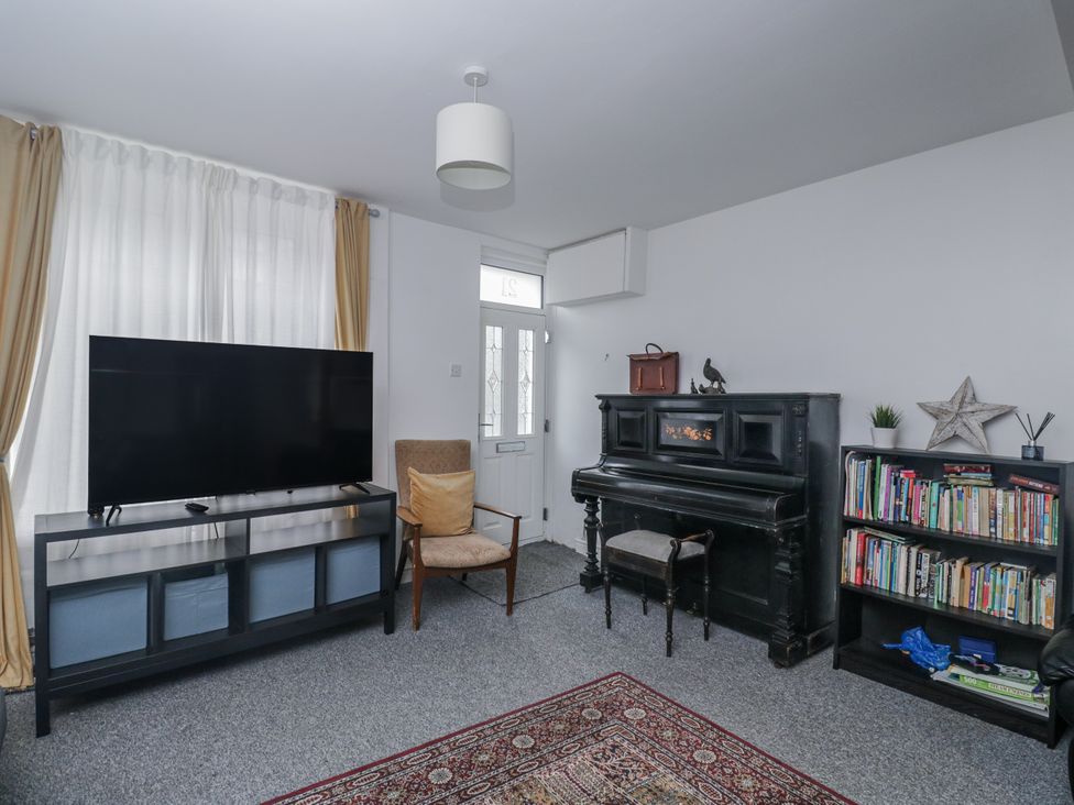 A living room with a television and piano at Maindy Lodge