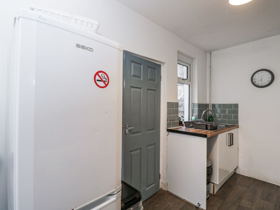 A kitchen with a refrigerator and sink at Maindy Lodge